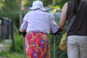 Seniorin erhält Unterstützung von Helferin, symbolisiert gesellschaftliche Herausforderungen älterer Menschen in NRW.