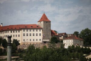 Prager Burg mit Warnhinweis zu Hepatitis A und Hygienemaßnahmen im Hintergrund.