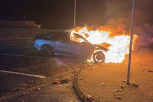 Brennendes Auto auf Nordfriedhof in Alsdorf, Feuerwehr beim Löschen, Polizei ermittelt.