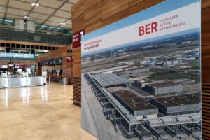 Flughafen BER mit Flugzeugen und passagierfreundlicher Architektur, symbolisiert finanzielle Eigenständigkeit und Wachstum.