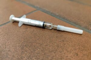 Heroin-Spritze symbolisiert die Gefahren synthetischer Drogen und drohender Überdosierungen in Bayern.