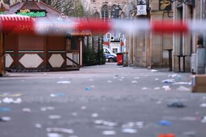 Gerichtssaal mit Angeklagtem, Weihnachtsmarkt-Hintergrund, Fokus auf bevorstehendem Prozess.
