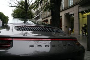 Porsche-Auto vor urbanem Hintergrund, symbolisiert Rückzug und Herausforderungen auf dem chinesischen Markt.