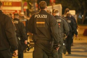 Polizisten sichern Fußballspiel zwischen Rot-Weiß Erfurt und Carl-Zeiss Jena mit Fans.
