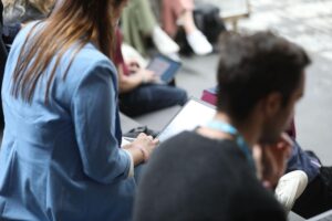 Junge Unternehmer mit Laptops, frustriert über Bürokratie und schlechte Gründungsbedingungen in Deutschland.