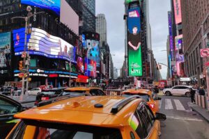 Menschen am Times Square, symbolisch für Rückgang deutscher Auswanderung in die USA.