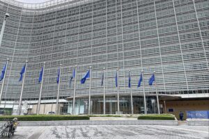 EU-Kommission genehmigt Zahlungen für Kohleausstieg in der Lausitz EU-Fahnen und Diskussion über Klimaneutralität Deutschlands bis 2045, Wirkung und Herausforderungen.