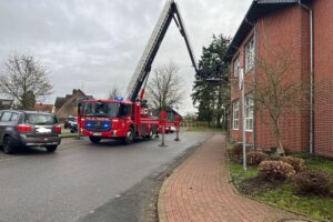 Feuerwehreinsatz mit medizinischer Notfallversorgung und Hubrettungsbühne zum Transport eines Patienten.