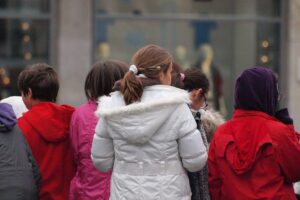 Eine Gruppe lachender Kinder, die Freude und Vielfalt symbolisieren, steht im Mittelpunkt des Bildes.