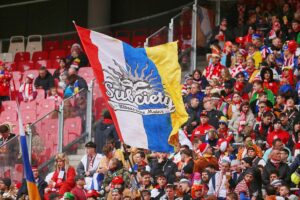 Fans von Mainz 05 feiern, während im Hintergrund die MEWA ARENA zu sehen ist.