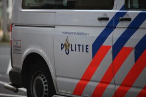 Polizisten durchsuchen ein Gebäude, beschlagnahmen Drogen und Beweismittel gegen Drogenbande.