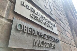 Gerichtssaal mit Sicherheitsvorkehrungen, Richter und Angeklagte wegen Terrorismusverdachts in München.