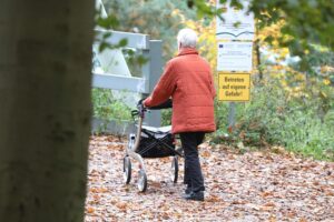 Seniorin, die besorgt auf Rentenvorschriften schaut, symbolisiert Rentendebatte und generationenübergreifende Verantwortung.