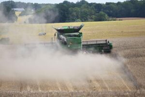 Mähdrescher im Einsatz auf einem Feld, symbolisiert Landwirtschaft und Unterstützung für junge Landwirte.