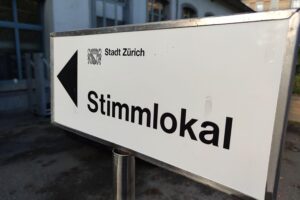 Wahllokal in Zürich: Bürger stimmen gegen Bürgerdienst und neue Erbschaftssteuer. Abstimmungsergebnis sichtbar.