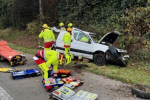 Schwerer Verkehrsunfall mit eingeklemmter Person auf Autobahn, Feuerwehr rettet Fahrer mit hydraulischem Gerät.