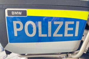 Eine verletzte Autofahrerin nach einem Unfall auf der Bundesstraße, Polizei und Rettungskräfte vor Ort.