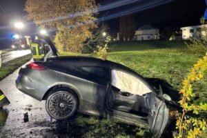 Schwerer Verkehrsunfall mit Auto, Baum und winterlichen Bedingungen auf der Straße.