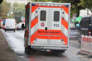 Rettungswagen vor einer Unfallstelle mit zwei beschädigten Pkw und Verletzten in Moers.