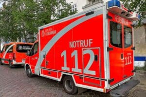 Rettungswagen vor Krankenhaus, symbolisiert Notfall und Verkehrsunfall eines Radfahrers in Berlin.