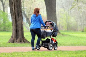 Mutter mit Kinderwagen zeigt Herausforderungen weiblicher Erwerbstätigkeit und wirtschaftlicher Eigenständigkeit in Familien.