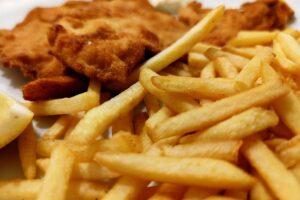 Pommes und Wiener Schnitzel auf Teller; thematisiert vegetarische Produkte und Verbraucherumfragen.