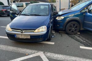 Unfallstelle mit beschädigten Fahrzeugen, Polizei vor Ort, verletzte Fahrer, Schadensaufnahme.