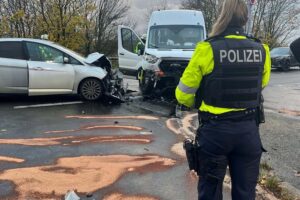 Verkehrsunfall auf Bundesstraße, Rettungskräfte helfen Verletzten, Polizei dokumentiert die Lage.