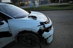 Ein Unfall im Kreisverkehr mit beschädigten Fahrzeugen und Polizei am Einsatzort.