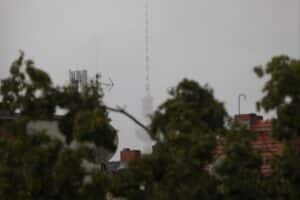 Berliner Fernsehturm unter grauem Himmel, umgeben von Nebel und trübem Wetter.