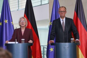 Monika Schnitzer übergibt Friedrich Merz das Jahresgutachten zur wirtschaftlichen Entwicklung in Deutschland.