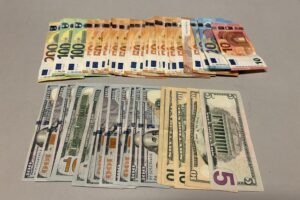 Sichergestelltes Bargeld und Waffen in einer Durchsuchung gegen illegalen Zigarettenhandel.