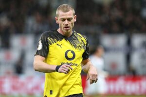 Fußballspieler celebrating goals, Emotionen, Spannung – Freiburg und Dortmund, intensives Bundesliga-Match.