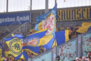 Fans in Stadion, leidenschaftlich und emotional, während eines aufgeladenen Fußballspiels zwischen Hannover 96 und Eintracht Braunschweig.