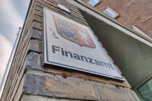 Eine gestresste Person wartet geduldig im Büro einer Behörde, um ihr Anliegen zu klären.
