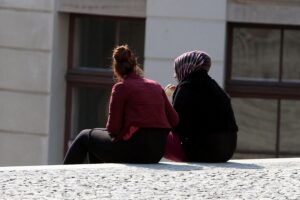 Zwei Frauen, eine mit Kopftuch, eine ohne, symbolisieren Vielfalt und Integration in Brandenburg.