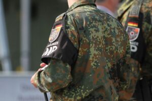 Junge Menschen protestieren gegen Wiedereinführung der Wehrpflicht, symbolisiert durch Schulstreiks und Diskussionen.