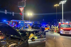 Drei beschädigte Fahrzeuge an unübersichtlicher Kreuzung, Feuerwehr und Polizei im Einsatz.