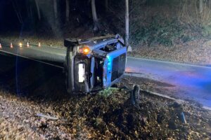 Ein überschlagenes Auto auf der Bundesstraße, Rettungswagen und Polizei vor Ort.