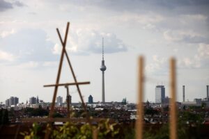 Dachterrasse in Berlin, Blick auf Fernsehturm, Symbol für nachhaltige Energiezukunft und -verbrauch.