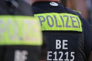 Bild von Polizei- und Feuerwehrkräften vor einem beschädigten Shisha-Laden nach Explosion.