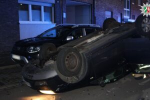Ein überschlagenes Auto nach einem Verkehrsunfall, Polizei vor Ort, abgeschleppte Fahrzeuge.