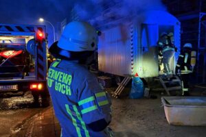 Brand im Bauwagen, ausgelöst durch defekten Akku; Feuerwehr im Einsatz zur Brandbekämpfung.