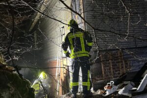 Feuerwehr öffnet Fassade, um Brandherd zu löschen und Glutnester zu erreichen.