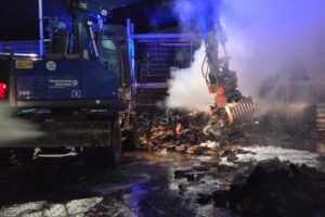 Feuerwehr beim Löschen eines Brandes in Wittenberg, Einsatzkräfte und Löschfahrzeuge sichtbar.