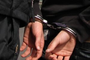Polizei hält Frau mit Handschellen fest, nachdem sie Brand unter S-Bahn-Unterführung gelegt hat.