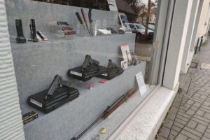 Waffenladen mit Schreckschusswaffen, Warnhinweise zur Gefahrenlage, Silvesterfeuerwerk im Hintergrund.