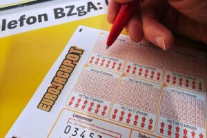 Ein Eurojackpot-Spielschein mit Gewinnzahlen und Warnhinweis zu Spielsucht und Steuerfreiheit.