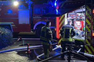 Großbrand auf Flugplatz: Zerstörte Hallen, Flugzeuge, Feuerwehr im Einsatz, Nacht-Szenario.