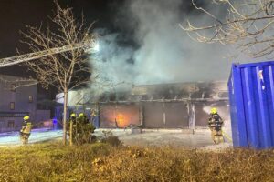 Großbrand in Sanitätshaus: Feuerwehr löscht Flammen, umfangreiche Löscharbeiten, keine Verletzten.